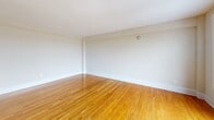 Located at 1629 Columbia Rd NW in Washington, DC's dynamic Adams Morgan neighborhood, this one-bedroom, one-bathroom residence offers a well-organized, efficiently laid-out living space across a single floor. Warm-toned hardwood floors flow throughout the unit, lending a cohesive and polished look to every room.

The living room is a bright, open area anchored by large windows and a glass balcony door that opens to a private outdoor balcony. From this elevated vantage point, sweeping panoramic views of Washington, DC's tree-lined rooftops and cityscape stretch into the distance — a standout feature of the space.

The bedroom is generously proportioned, offering a wide bay of windows that frame additional city views and fill the room with natural light. A double-door closet provides ample storage, keeping the space functional and organized.

The kitchen, visible from the floor plan, features a peninsula-style layout that separates it from the living area. The bathroom is finished with light-toned tile flooring, white subway-style wall tile wainscoting, a natural-light window, and a wall-mounted grab bar, adding both practicality and a clean, neutral aesthetic.

A connecting hallway ties all rooms together, completing this well-appointed urban residence.