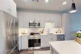 This thoughtfully designed one-bedroom, one-bathroom residence at 3300 Toledo Rd in Hyattsville, MD offers a comfortable and modern living experience across a well-utilized single floor. The open-concept layout seamlessly connects the kitchen, dining, and living areas, creating an airy and cohesive flow throughout the space. The contemporary kitchen is a standout feature, showcasing sleek light grey cabinetry extending to the ceiling, white quartz countertops, a classic subway tile backsplash, stainless steel appliances including a gas range, built-in microwave, dishwasher, and refrigerator, and a kitchen island illuminated by stylish pendant lighting. Rich hardwood-style flooring runs throughout the main living areas. The living room is bright and welcoming, benefiting from large windows that frame neighborhood views and invite abundant natural light. The bedroom is a tranquil retreat, offering generous proportions, large windows with exterior views, and ample closet storage. The bathroom features a clean, all-white tiled tub-shower combination. Additional highlights include a private balcony, dedicated laundry, and two closets, making this residence as functional as it is stylish.
