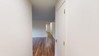 Located at 2001 Huron Parkway in Ann Arbor, MI, this 2-bedroom, 1-bathroom unit offers a well-organized single-floor layout with hardwood-style flooring throughout. The combined kitchen and living area forms the heart of the home, with the kitchen featuring white shaker cabinetry, stainless steel appliances including a refrigerator, range, and microwave, and light countertops. The open connection to the living room provides a functional and cohesive living space. The living room is bright and airy, with windows that invite natural light and offer views of the surrounding neighborhood greenery. Baseboard heating runs along the walls, ensuring comfort throughout the colder Michigan months. The primary bedroom is a comfortable, well-proportioned room with two windows on adjacent walls, filling the space with natural light and views of the lush outdoor surroundings. The second bedroom includes a built-in closet with bi-fold doors, adding practical storage. The bathroom is clean and modern, featuring a glass sliding-door shower with white tile surround, a vanity with storage cabinetry, and hardwood-style flooring. Two hallways connect the rooms efficiently, and an additional dedicated closet provides extra storage. The overall aesthetic is clean and neutral throughout.