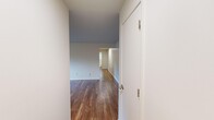 Located at 2001 Huron Parkway in Ann Arbor, MI, this 2-bedroom, 1-bathroom unit offers a well-organized single-floor layout with hardwood-style flooring throughout. The combined kitchen and living area forms the heart of the home, with the kitchen featuring white shaker cabinetry, stainless steel appliances including a refrigerator, range, and microwave, and light countertops. The open connection to the living room provides a functional and cohesive living space. The living room is bright and airy, with windows that invite natural light and offer views of the surrounding neighborhood greenery. Baseboard heating runs along the walls, ensuring comfort throughout the colder Michigan months. The primary bedroom is a comfortable, well-proportioned room with two windows on adjacent walls, filling the space with natural light and views of the lush outdoor surroundings. The second bedroom includes a built-in closet with bi-fold doors, adding practical storage. The bathroom is clean and modern, featuring a glass sliding-door shower with white tile surround, a vanity with storage cabinetry, and hardwood-style flooring. Two hallways connect the rooms efficiently, and an additional dedicated closet provides extra storage. The overall aesthetic is clean and neutral throughout.
