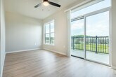 Located at 2692 Botanical Dr in Fitchburg, Wisconsin, this thoughtfully designed one-bedroom, one-bathroom unit offers a bright and functional single-floor layout. Light hardwood flooring flows throughout, complementing the neutral warm-toned walls and clean white trim that give the space a modern, cohesive feel.

The combined kitchen and living area serves as the heart of the unit. The kitchen is well-appointed with white shaker-style cabinetry, stainless steel appliances including a range, microwave, refrigerator, and dishwasher, light countertops, and a classic subway tile backsplash. Generous built-in shelving and additional cabinetry provide ample storage. The living area benefits from a sliding glass door opening to a private balcony, filling the space with natural light and offering open scenic views of the surrounding landscape.

The bedroom is a comfortable, sunlit retreat featuring a large picture window with expansive outdoor views and a ceiling fan. It connects conveniently to the bathroom, which includes white cabinetry, a well-lit vanity mirror, and a stacked in-unit washer and dryer. Two closets provide additional storage throughout the unit. The overall ambiance is clean, bright, and move-in ready, ideal for those seeking a well-organized and efficient living space.