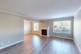 Located on Antoinette Lane in South San Francisco, this two-story home offers four bedrooms, one bathroom, and a thoughtfully designed layout spread across two floors. The main floor opens into a spacious living room finished with gleaming hardwood-style flooring, elegant crown molding, and a classic white-surround fireplace as its focal point. Large windows flood the room with natural light and offer pleasant outdoor views. The adjoining kitchen is well-appointed with rich wood cabinetry, quartz countertops, a tile backsplash, stainless steel appliances, and a generous sink — all set atop light hardwood-style floors. Upstairs, the four bedrooms are carpeted for comfort and feature neutral tones, wide windows with outdoor views, ceiling fans, and sliding-door closets with built-in shelving. The primary bedroom offers a notably generous footprint among the four. The shared bathroom showcases a modern vanity with a quartz countertop, warm wood cabinetry, and a sleek rectangular mirror. Throughout the home, clean lines, neutral color palettes, and quality finishes create a bright, move-in-ready atmosphere suited for a variety of lifestyles.