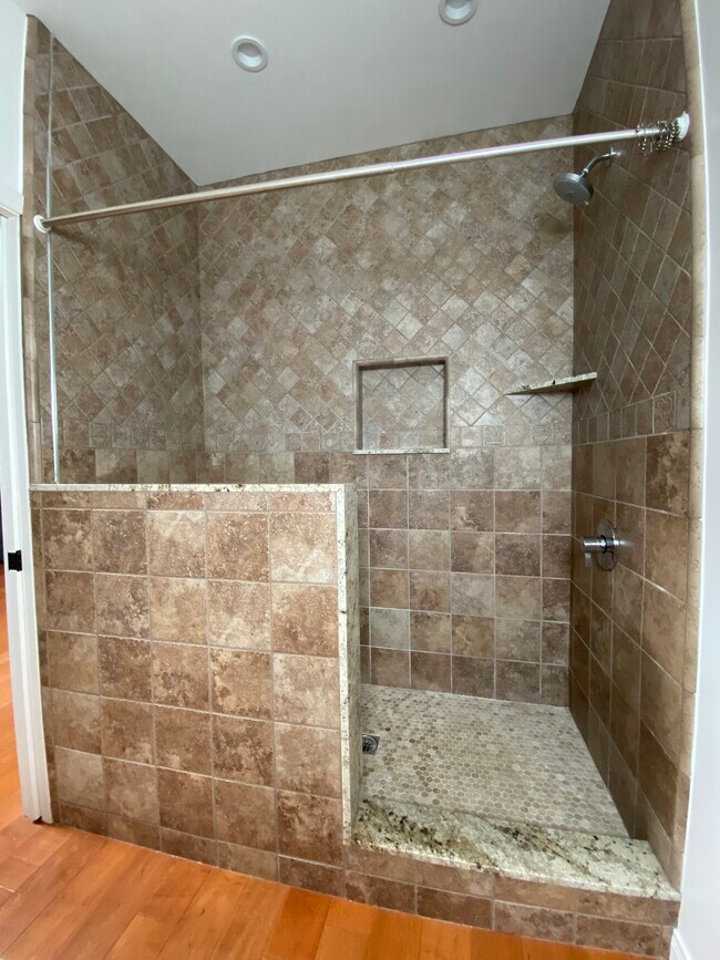 Amplia ducha a ras de suelo con azulejos y banco. - 10563 Cushdon Ave