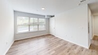 This well-appointed two-bedroom, one-bathroom residence in Bethlehem, PA offers a thoughtfully designed single-floor layout. The open-concept kitchen is a standout feature, showcasing grey shaker-style cabinetry, striking granite countertops with bold veining, a matching granite-topped island, a full marble-look tile backsplash, and a complete suite of stainless steel appliances. Light hardwood flooring flows through the main living areas, connecting the kitchen to the adjacent dining and living rooms, which are bathed in natural light from large windows with outdoor views. The living area also features recessed lighting and a convenient electrical panel. Both bedrooms are finished with plush carpeting and include closet space — the primary bedroom benefits from a spacious walk-in closet with wire shelving. The second bedroom also features a windowed wall and direct closet access. The bathroom is finished with a full soaking tub and shower combo with brushed gold fixtures and patterned tile flooring. Three closets total provide excellent storage throughout. A connecting hallway ties all rooms together in a clean, efficient layout, making this a highly functional and modern living space.