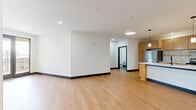 Located at 320 S Shelby St in Louisville, KY, this two-bedroom, two-bathroom apartment offers a well-designed single-floor layout with modern finishes and a cohesive contemporary aesthetic throughout. Light-toned hardwood-style flooring flows seamlessly across the entire unit, complemented by crisp white walls and bold dark baseboards and door frames that create a clean, modern contrast.

The open-concept living, dining, and kitchen area forms the heart of the unit. The kitchen is thoughtfully appointed with warm natural wood cabinetry, a subway tile backsplash, stainless steel appliances, and a spacious island with a white countertop and integrated sink, illuminated by stylish pendant lighting. The living area opens directly to a private outdoor balcony through large black-framed glass doors, offering open views of the surrounding community.

The two bedrooms are well-proportioned, with one featuring a ceiling fan and a window with natural light. Both rooms include access to closets equipped with wire shelving systems for organized storage. The two bathrooms are finished with hexagonal gray tile flooring and frameless sliding glass shower enclosures, delivering a clean, upscale feel. A dedicated in-unit laundry area adds everyday convenience to this well-rounded urban residence.