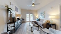 Located at 100 Harley Ln in Pooler, Georgia, this single-floor residence offers a thoughtfully designed layout with contemporary finishes and a cohesive coastal-inspired aesthetic. Light wood-tone flooring runs throughout, tying each room together seamlessly.

The living area serves as the heart of the home, featuring a ceiling fan, neutral walls, and a set of French doors that invite natural light and provide access to an outdoor area. The space is open and comfortable, offering a relaxed yet polished atmosphere.

The galley-style kitchen is efficiently designed with gray shaker cabinetry, granite countertops, a white subway tile backsplash, and a full suite of stainless steel appliances including a refrigerator, range, microwave, and dishwasher. Track and pendant lighting illuminate the workspace effectively.

Multiple bedrooms provide restful retreats, each featuring ceiling fans, ample natural light from large windows dressed with decorative curtains, and consistent wood-tone flooring. The primary bedroom is generously sized with a bright, airy feel.

The bathroom is clean and functional, finished in white tones with a full tub-shower combination and wood-look flooring. The overall design of this residence balances modern convenience with a warm, inviting ambiance suited for comfortable everyday living.