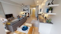 Located at 117 N Cleveland St in Oceanside, CA, this modern studio offers a thoughtfully designed open-plan layout that seamlessly integrates the living, sleeping, and dining areas. Light hardwood flooring runs throughout, complementing the clean, neutral color palette and recessed lighting that brightens the entire space.

The kitchen is a standout feature, outfitted with stainless steel appliances — including a gas range, microwave, refrigerator, and dishwasher — paired with white cabinetry, dark countertops, and a classic subway tile backsplash. Open shelving provides additional storage and display space, while the adjacent dining area accommodates a compact table for everyday meals.

The living area is anchored by a comfortable sofa and a stylish round accent chair, with a TV console positioned beside a concrete architectural column. A large sliding glass door fills the space with natural light and opens to a private balcony, enhancing the airy ambiance. A ceiling fan adds to the comfort of the combined living and sleeping zone, where a full-sized bed is neatly framed by a bold wall-mounted artwork.

The bathroom is clean and modern, featuring a single-sink vanity with dark countertops, a large mirror, built-in shelving, and a walk-in shower, all finished in crisp white tones with wood-look flooring.