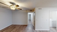 This single-floor residence in Alabaster, Alabama offers a well-designed layout with clean, updated finishes throughout. The main living area features warm wood-look luxury vinyl plank flooring, a ceiling fan with light fixture, and a textured ceiling, creating a comfortable and functional space. A central hallway connects the living area to the rest of the home, providing a logical and efficient flow between rooms.

The kitchen is a standout feature, outfitted with crisp white shaker-style cabinetry, granite-look countertops, and a full suite of stainless steel appliances including a range, over-the-range microwave, and refrigerator. The bedrooms are carpeted for comfort and each includes a ceiling fan and window with blinds that frame lush, green outdoor views, filling the rooms with natural light.

Two bathrooms serve the home. One features a tub-shower combination with clean white surroundings and a vanity with granite-look countertops. The second bathroom offers a standalone glass-door shower stall, a matching vanity, and a window for natural light and ventilation. Both bathrooms include wood-look flooring. A dedicated laundry room houses a full-size washer and dryer along with a water heater, providing added convenience and practicality within the home.