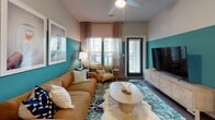 Located at 3000 Cypress Lake Rd in North Charleston, SC, this thoughtfully designed single-story residence offers a curated blend of bold aesthetics and functional living. The open-concept living area makes a strong visual statement with a two-tone teal accent wall, wood-look flooring, ceiling fan, and large windows that allow natural light to filter through sheer patterned curtains. A peninsula with dark granite countertops bridges the living space to the kitchen, which features white shaker cabinetry, subway tile backsplash, stainless steel appliances including a side-by-side refrigerator, and a decorative lattice wine rack above the upper cabinets. A compact dining nook near the entry showcases eye-catching moon-phase wallpaper, dark doors, and wood-look flooring. Each of the two bedrooms is distinctly styled with statement wallpapered accent walls, ceiling fans, large windows with natural light, and plush area rugs. The bathrooms include dark granite vanity tops with undermount sinks, wood-look flooring, and a tub-shower combination. Throughout the residence, consistent design details—dark door frames, durable flooring, and curated finishes—create a cohesive and contemporary ambiance.