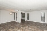 Located at 4946 Snapfinger Woods Dr in Decatur, GA, this single-floor unit offers a cohesive and functional layout designed for comfortable everyday living. Rich, dark hardwood-style flooring runs consistently throughout the space, creating a unified aesthetic from room to room.

The open-concept living and dining area is generously proportioned, with multiple windows fitted with horizontal blinds that allow natural light to filter in while maintaining privacy. A pendant light fixture anchors the dining area, and a textured ceiling adds architectural character to the shared living space.

The kitchen is well-equipped, featuring white cabinetry with brushed nickel hardware, granite-style countertops, a mosaic tile backsplash, and black appliances including a range and refrigerator. The layout provides ample counter and storage space for everyday use.

The bedrooms are spacious and bright, each with access to closet storage and connected to the hallway via white interior doors. The bathroom includes an extended vanity with granite-style countertops, dual mirrors, and a separate tub and shower area, providing both function and comfort.

Throughout the unit, neutral gray wall tones complement the flooring and cabinetry, resulting in a clean, modern interior that is move-in ready.