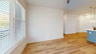 Located at 523 N Spring St in Greensboro, NC, this well-appointed one-bedroom, one-bathroom unit offers a clean, modern aesthetic throughout its efficiently designed single-floor layout. Light-toned luxury vinyl plank flooring runs continuously through the space, complementing the crisp white walls and creating a bright, cohesive atmosphere.

The open-concept living, dining, and kitchen area forms the heart of the unit. The kitchen is a standout feature, showcasing white shaker-style cabinetry, a classic subway tile backsplash, sleek quartz countertops, and a suite of stainless steel appliances including a refrigerator, electric range, and microwave. A central island with an undermount sink and pendant lighting overhead adds both functionality and style to the space.

The living area benefits from generous natural light through large windows with blinds and direct access to a private balcony, where a ceiling fan adds comfort. The bedroom is a comfortable, well-lit retreat with a window offering outdoor views and two dedicated closets for ample storage. A dedicated laundry area houses a full-size stacked washer and dryer, adding everyday convenience. The unit's clean, modern finishes and practical layout make it a highly functional living space.