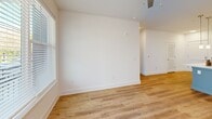 Located at 523 N Spring St in Greensboro, NC, this well-appointed one-bedroom, one-bathroom unit offers a clean, modern aesthetic throughout its efficiently designed single-floor layout. Light-toned luxury vinyl plank flooring runs continuously through the space, complementing the crisp white walls and creating a bright, cohesive atmosphere.

The open-concept living, dining, and kitchen area forms the heart of the unit. The kitchen is a standout feature, showcasing white shaker-style cabinetry, a classic subway tile backsplash, sleek quartz countertops, and a suite of stainless steel appliances including a refrigerator, electric range, and microwave. A central island with an undermount sink and pendant lighting overhead adds both functionality and style to the space.

The living area benefits from generous natural light through large windows with blinds and direct access to a private balcony, where a ceiling fan adds comfort. The bedroom is a comfortable, well-lit retreat with a window offering outdoor views and two dedicated closets for ample storage. A dedicated laundry area houses a full-size stacked washer and dryer, adding everyday convenience. The unit's clean, modern finishes and practical layout make it a highly functional living space.