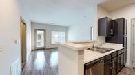 Located at 2550 Pillow Dr in Columbia, Tennessee, this single-floor, three-bedroom, two-bathroom residence offers a practical and well-appointed layout. The open-concept kitchen and living area serves as the heart of the home, featuring a peninsula with light stone countertops, dark espresso cabinetry, stainless steel appliances including a dishwasher and refrigerator, and hardwood-style flooring that extends into the living space. Large windows and a glass door in the living area invite abundant natural light and provide outdoor views. The three bedrooms are carpeted for comfort, each equipped with a ceiling fan and windows that allow ample daylight — the primary bedroom offering a generous footprint. Four closets throughout the home provide excellent storage. Both bathrooms feature hardwood-style flooring, dark vanity cabinetry with stone countertops, and tub/shower combinations. A dedicated laundry room with a full-size washer and dryer adds everyday convenience. A central hallway connects the rooms efficiently, completing a cohesive and functional floor plan designed for comfortable single-level living.