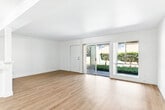 Located at 855 S Citrus Ave in Azusa, CA, this one-bedroom, one-bathroom residence offers a thoughtfully laid-out single-floor plan with a clean, bright aesthetic throughout. Light wood-style flooring flows consistently across all rooms, complementing the crisp white walls and creating a cohesive, airy feel.

The combined kitchen and living area forms the heart of the home. The kitchen is well-equipped with abundant white shaker cabinetry, sparkling quartz countertops, a matching quartz breakfast bar, and a double-basin sink. The living room receives generous natural light through large sliding glass doors that open to a landscaped outdoor area, providing a seamless indoor-outdoor connection. A ceiling fan adds comfort to the living space.

A central hallway connects the main living areas to the private quarters. The bedroom is a comfortable, well-proportioned room featuring its own sliding glass door for additional natural light and outdoor access, along with a dedicated closet with built-in rod and shelving. The full bathroom includes a tiled shower/tub combination with glass enclosure, a white vanity with ample counter space, and a wall mirror. The hallway provides additional storage via a closet. Overall, the space presents a clean, functional, and welcoming environment.
