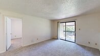 Located at 2201 NW 122nd St in Oklahoma City, Oklahoma, this two-bedroom, two-bathroom home spans two floors and offers a well-organized, functional layout. The main living level hosts the majority of the space, including a carpeted living room that serves as the heart of the home. Large sliding glass doors in the living room open to a private balcony, flooding the area with natural light and providing pleasant outdoor views of surrounding greenery. The textured ceilings are consistent throughout, lending a classic residential character to the space. The kitchen features warm wood-toned cabinetry and is conveniently positioned near the living area, as seen in the floor plan. Both bedrooms are carpeted and bright, each benefiting from natural light through windows fitted with blinds. The primary bedroom offers a comfortable, generously sized footprint with its own dedicated closet. Both bathrooms share a consistent design aesthetic, featuring white tile tub-and-shower combinations, wood-toned vanity cabinetry, light countertops, and wood-look flooring, creating a clean and cohesive look. A dedicated laundry area and additional closet storage add practical convenience. A staircase connects the two levels, completing this thoughtfully arranged home.
