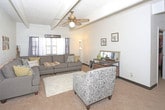Located at 2601 York Ave in Lubbock, Texas, this single-floor home offers a warm and functional layout with distinct character throughout. The living area is a standout space, featuring exposed beam ceilings with textured tile panels and brick accent walls that lend a retro yet cozy charm. Natural light filters in through shuttered windows dressed with sheer curtains, creating a comfortable atmosphere. A ceiling fan adds practical comfort, while the room provides ample space for relaxed seating arrangements. An electric fireplace serves as a focal point on one wall, complementing the carpeted floors and plush area rug underfoot. The bedroom continues the architectural theme with beamed ceilings and exposed brick walls, offering an intimate and restful retreat. A window with vibrant curtains allows for natural light while maintaining privacy. The kitchen is compact and efficiently laid out, featuring warm wood cabinetry with classic hardware, a built-in electric range, a single-basin sink, and tile backsplash accents. Vinyl plank flooring grounds the space practically. The bathroom includes a wood-toned vanity with a light countertop, a mirrored medicine cabinet, towel storage, and a shower-tub combination, providing all essential amenities in a neatly arranged layout.