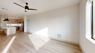 Located at 4900 East Deer Valley Drive in Phoenix, AZ, this thoughtfully designed 2-bedroom, 2-bathroom residence offers a clean, modern aesthetic across a single floor. The open-concept living room and kitchen area is anchored by light hardwood flooring, crisp white walls, and large windows that flood the space with natural light. A ceiling fan adds comfort, while a sliding glass door provides access to an outdoor area with views of surrounding desert landscaping and palm trees.

The kitchen is a standout feature, showcasing floor-to-ceiling taupe cabinetry with matte black hardware, white quartz countertops, a waterfall island with an undermount sink, and stainless steel appliances. A statement pendant light adds a modern touch above the island.

The spacious primary bedroom is carpeted and benefits from generous natural light. It is complemented by a well-organized walk-in closet with built-in shelving and hanging rods. The primary bathroom features a walk-in marble-tiled shower with a frameless glass enclosure and black accents. The second bathroom mirrors the same refined style with a wide vanity, white quartz countertop, large mirror, and a tiled shower. Both bedrooms offer a calm, neutral palette with plush carpet flooring and ample window views.