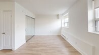 Located at 205-207 Morningside Ave in Toronto's Morningside neighbourhood, this ground-floor unit offers a clean, modern interior across a single level. The open-concept layout seamlessly connects the kitchen and living area, creating a functional and airy feel. Light-toned laminate flooring runs throughout, complementing the bright white walls and lending a fresh, cohesive look to the space.

The kitchen is well-appointed with white shaker-style cabinetry, dark countertops, and a classic white subway tile backsplash. A full suite of stainless steel appliances — including a refrigerator, stove, dishwasher, and built-in microwave — provides modern convenience. The living area benefits from a large multi-pane window fitted with a roller blind, alongside a classic cast-iron radiator that provides radiant heating.

The bedroom is a well-proportioned, bright room featuring a mirrored sliding closet, a window with natural light, and a baseboard heater. The bathroom is finished with white subway tile surrounding a full soaker tub and shower combination, with neutral floor tiling and clean fixtures throughout.

The unit's consistent white palette, updated finishes, and natural light create a bright and welcoming ambiance throughout.