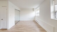 Located at 205-207 Morningside Ave in Toronto's Morningside neighbourhood, this ground-floor unit offers a clean, modern interior across a single level. The open-concept layout seamlessly connects the kitchen and living area, creating a functional and airy feel. Light-toned laminate flooring runs throughout, complementing the bright white walls and lending a fresh, cohesive look to the space.

The kitchen is well-appointed with white shaker-style cabinetry, dark countertops, and a classic white subway tile backsplash. A full suite of stainless steel appliances — including a refrigerator, stove, dishwasher, and built-in microwave — provides modern convenience. The living area benefits from a large multi-pane window fitted with a roller blind, alongside a classic cast-iron radiator that provides radiant heating.

The bedroom is a well-proportioned, bright room featuring a mirrored sliding closet, a window with natural light, and a baseboard heater. The bathroom is finished with white subway tile surrounding a full soaker tub and shower combination, with neutral floor tiling and clean fixtures throughout.

The unit's consistent white palette, updated finishes, and natural light create a bright and welcoming ambiance throughout.