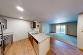 Located in Snoqualmie, WA, this 2-bedroom, 2-bathroom residence offers a well-organized single-floor layout designed for comfortable everyday living. The open-concept kitchen and living area form the heart of the home, where warm hardwood-style flooring transitions seamlessly into a carpeted living room. The kitchen features a central peninsula with a double stainless steel sink, dark espresso cabinetry, stainless steel appliances including a refrigerator, microwave, and range, and recessed lighting overhead. The adjoining living room is generously sized with plush carpet and sliding glass doors that open to a private balcony, bringing in natural light and outdoor views. A dedicated dining area sits conveniently between the kitchen and living spaces. The primary bedroom offers a comfortable footprint with carpeted flooring, a closet, and direct access to a private bathroom. The second bedroom features carpet, a window with neighborhood views, and easy access to the second full bathroom. Both bathrooms are finished with herringbone-patterned tile flooring, dark wood vanities, and clean white fixtures, with one including a full soaking tub and shower combination. Additional highlights include in-unit laundry, a hallway with multiple closets for ample storage, and a practical, efficient layout throughout.