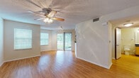 Located at 95 Lifestyle Blvd in Palm Harbor, Florida, this single-story residence offers a well-organized layout with a comfortable, functional design throughout. The living area serves as the heart of the home, featuring warm wood-style flooring, neutral walls, and a ceiling fan with integrated lighting. Natural light fills the space through multiple windows and a sliding glass door that opens to an outdoor area, creating a bright and airy atmosphere. A pass-through window with a dark countertop connects the living area to the kitchen, enhancing the open feel between the two spaces.

The galley-style kitchen is equipped with black appliances, including a range, over-the-range microwave, and refrigerator. Light wood cabinetry pairs with dark countertops and a mosaic tile backsplash to create a practical and visually cohesive workspace. A louvered door provides access to an adjacent area, adding to the kitchen's utility.

The bedroom features plush carpeting, a window with blinds, and a textured ceiling, offering a quiet and comfortable retreat. The bathroom includes wood-style flooring, a vanity with dark countertop and light wood cabinetry, a tiled tub-and-shower combination, and accessibility-friendly grab bars. Throughout the residence, consistent flooring and neutral tones create a cohesive, inviting ambiance.