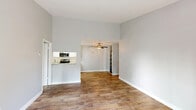 Located at 2275 S Bascom Ave in San Jose, CA, this single-floor residence offers four bedrooms and two full bathrooms within a well-organized layout. The open living area is finished with warm wood-look flooring and features a ceiling fan overhead, while a sliding glass door floods the space with natural light and provides access to an outdoor area with greenery views. The galley-style kitchen is well-appointed with white cabinetry, light stone countertops, a stainless steel microwave, electric range, dishwasher, and refrigerator, all complemented by a skylight above. The bedrooms are carpeted for comfort, with windows that bring in natural light; baseboard heating units are present for year-round comfort. A dedicated closet provides additional storage. Both bathrooms are finished in a clean, neutral palette, each featuring a full tub-shower combination, a vanity with stone countertop, white cabinetry, and wood-look tile flooring. The throughout neutral gray wall tones create a bright, cohesive aesthetic across the entire residence, offering a clean and move-in-ready environment suited for a range of living arrangements.