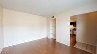 This single-floor residence offers a well-organized layout with a variety of thoughtful design details throughout. The living areas are characterized by warm hardwood-style flooring and striking painted brick accent walls that lend a distinctive, textural character to the space. A textured ceiling runs throughout, adding depth to each room. The living room features built-in open shelving recessed into the wall, providing practical storage and display space, alongside a window that brings in natural light and outdoor views.

The kitchen is well-appointed with dark espresso cabinetry, granite-style countertops, a gas range, stainless steel dishwasher, and a double sink. A painted brick wall continues into the kitchen, maintaining a cohesive aesthetic. The bedrooms are carpeted for comfort and each benefit from windows with blinds that allow for natural light while maintaining privacy. The painted brick walls extend into the bedroom areas as well, reinforcing the consistent design theme.

The bathroom is clean and functional, featuring a tiled shower-tub combination with a window above, a dark vanity with a granite-style countertop, a single sink, and hardwood-style flooring. The overall ambiance of this residence is warm and practical, with a blend of classic brick texturing and modern finishes throughout.