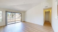 This single-story, 3-bedroom, 2-bathroom home in Vista, CA offers a clean and functional layout with consistent light wood flooring throughout. The open living room serves as the heart of the home, highlighted by a classic brick fireplace with a white mantel and multiple windows that fill the space with natural light. Adjacent to the living area, the kitchen is well-appointed with warm wood cabinetry, granite countertops, stainless steel appliances including a refrigerator and range, and a peninsula that provides additional prep space and casual seating. A chandelier above the dining area adds a touch of character to the space. The primary bedroom is a comfortable size, accompanied by a walk-in closet outfitted with built-in shelving and hanging rods, as well as an en-suite bathroom featuring a granite-topped vanity with rich wood cabinetry. The second bathroom includes a full tub-shower combination. The two additional bedrooms are bright and neutrally finished, each offering a clean canvas for personal use. Throughout the home, neutral white walls and light flooring create a cohesive, airy atmosphere. A hallway connects the bedroom wing to the main living areas, contributing to the home's practical and straightforward flow.