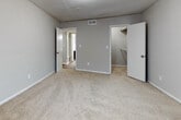 Located at 2515 Northeast Expressway in Atlanta, Georgia, this single-floor residence offers a practical and well-organized layout with a consistent, neutral design throughout. The living area is a standout feature, showcasing rich wood-look plank flooring and a large sliding glass door dressed with vertical blinds that invites natural light into the space. A pendant light fixture and a front entry door anchor the open living and dining area, which flows easily through the unit.

The kitchen is efficiently designed with dark espresso cabinetry, light speckled countertops, a subway tile backsplash, and black gas appliances, including a range and oven. Wood-look flooring continues into this space, complementing the cabinetry tones.

The bedrooms feature plush wall-to-wall carpeting in a warm neutral tone, with windows that provide natural light and outdoor views of surrounding greenery. Each bedroom includes closet storage, with at least one room offering a spacious walk-in style closet. Textured ceilings are consistent throughout the home.

The bathroom is cleanly appointed with a dark-cabinet vanity, speckled countertop, an integrated sink, wood-look flooring, and a tiled shower and tub combination. The overall ambiance of the unit is clean, move-in ready, and functional.