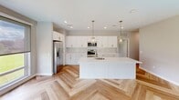 Located at 950 Trout Brook Drive in West Hartford, CT, this thoughtfully designed residence offers three bedrooms and three bathrooms across a single, efficiently laid-out floor. The open-concept kitchen and living area serve as the heart of the home, showcasing striking herringbone-patterned hardwood floors, crisp white shaker cabinetry with gold hardware, quartz countertops, a large center island with an undermount sink, a marble-style tile backsplash, and stainless steel appliances. Elegant gold pendant lights add a refined finishing touch overhead. The living area is bathed in natural light through large windows with roller shades, offering views of the surrounding West Hartford neighborhood. Each bedroom features light hardwood flooring, neutral toned walls, generous closet space, and large windows that invite ample daylight. The bathrooms are clean and modern, with one featuring floor-to-ceiling gray tile surrounding a glass-enclosed walk-in shower, while another offers a sleek vanity with a contemporary globe light fixture. Throughout the residence, recessed lighting, clean lines, and a cohesive neutral palette create a bright, polished, and welcoming atmosphere ideal for contemporary living.