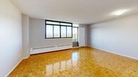 This efficient one-bedroom, one-bathroom unit is thoughtfully laid out across a single floor, offering a practical and comfortable living environment. Warm parquet flooring runs throughout the space, lending a classic character to every room.

The living room is the centerpiece of the unit, offering generous proportions and a wide bank of windows that frame sweeping elevated views of the city skyline and surrounding greenery. A baseboard heating system lines the perimeter, and the bright, neutral walls enhance the sense of openness and light.

The kitchen has been renovated to a high standard, featuring crisp white cabinetry with brushed nickel hardware, a marble-veined quartz countertop, a stainless steel undermount sink, and a matching subway tile backsplash that ties the design together cohesively.

The bedroom is a comfortably sized retreat with the same parquet flooring, large windows offering outdoor views, and a baseboard heater, creating a bright and functional space.

The bathroom is finished with floor-to-ceiling marble-effect tile surrounding a full soaking tub and shower combination, presenting a clean and elegant aesthetic.

The unit also includes a dedicated entrance, hallway, and additional storage space, completing a well-organized and move-in ready layout suited for urban living.