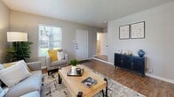 This two-story home in Dallas, Texas offers a practical and well-appointed layout spread across two floors. The main level features a bright living room with wood-look flooring, large windows that invite natural light, and a textured ceiling. Adjacent to it, the dining room accommodates a full-sized table and benefits from multiple windows with outdoor views. The kitchen is fully equipped with gray shaker-style cabinetry, granite countertops, a tile backsplash, black appliances, and tile flooring, providing ample workspace and storage. A utility room and hallway complete the ground floor. Upstairs, the spacious primary bedroom features plush carpeting, dual windows, and a ceiling fan with light fixture. The second bedroom, also carpeted, includes a ceiling fan and windows, making it well-suited as a guest room or home office. Both bathrooms are finished with gray vanity cabinetry and granite countertops. Each bedroom is complemented by a dedicated closet. The staircase connects both levels efficiently, and the overall color palette of soft grays and warm neutrals lends a cohesive, modern aesthetic throughout the home.