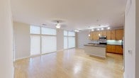 Located at 9532 Spirit of Austin Ln in Austin, TX, this single-floor unit offers a thoughtfully designed open-concept layout that seamlessly connects the living area to the kitchen. Light hardwood flooring runs throughout the main living spaces, complemented by a bright, neutral color palette that enhances the airy feel of the interior.

The kitchen is a standout feature, equipped with warm maple cabinetry, dark granite countertops, a tile backsplash, and a full suite of stainless steel appliances including a refrigerator with ice maker, range, and microwave. A center island with a built-in sink and pendant lighting above serves as both a functional workspace and a natural gathering point. Track lighting overhead provides additional illumination throughout the kitchen and living areas.

The living area is bathed in natural light through a series of large floor-to-ceiling windows fitted with roller shades, creating a bright and welcoming atmosphere. A light-filled entry door with a sidelite panel adds to the openness of the space.

The bedroom features plush carpeting and connects directly to a full bathroom with dual sinks, granite countertops, maple cabinetry, and a soaking tub. A spacious walk-in closet with built-in shelving and hanging rods provides generous storage. An additional walk-in closet and built-in wall shelving elsewhere in the unit offer further organizational versatility.