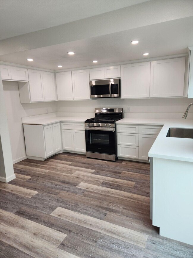 Cocina equipada con estufa, microondas y lavavajillas. - 443 E Park Ave