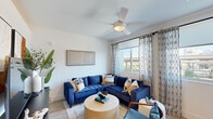 Located at 2500 East Marco Polo Road in Phoenix, AZ, this well-designed one-bedroom, one-bathroom unit offers a smart and functional layout across a single floor. Light wood-look flooring runs throughout, creating a cohesive and contemporary feel.

The living room is bright and inviting, featuring a ceiling fan with light kit and large windows dressed with sheer patterned curtains that allow natural light to filter in while offering outdoor views of the surrounding Phoenix landscape.

The galley-style kitchen is efficiently laid out and finished with light wood cabinetry, white quartz countertops, a white subway tile backsplash, and matte black hardware. Stainless steel appliances — including a refrigerator, range, microwave, and dishwasher — provide a modern, functional cooking space. A sliding barn door adds a stylish architectural touch at the kitchen entrance.

The bedroom is a calm and restful retreat with clean white walls, a ceiling fan, and an arched doorway that connects to the adjacent spaces. Its cozy scale makes for an intimate setting.

The bathroom features warm wood vanity cabinetry, white quartz countertops, matte black fixtures, a tiled tub-shower combination, and wood-look flooring, tying together the home's consistent modern aesthetic throughout.