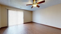 Located at 1907 W 24th Ave in Emporia, Kansas, this single-floor, 2-bedroom, 2-bathroom home offers a practical and comfortable layout with consistent finishes throughout. The living room is a welcoming space highlighted by wood-look flooring, a ceiling fan with light fixture, a textured ceiling, and a sliding glass door fitted with vertical blinds that allows natural light and outdoor views. An open-concept design connects the living and dining areas to the kitchen, which features rich, dark wood cabinetry, a peninsula with a breakfast bar, stone-look countertops, and tile flooring — creating a clear and functional transition between living and cooking spaces. Both bedrooms are well-proportioned, with the primary bedroom offering generous square footage, wood-look flooring, a large window with blinds, and a ceiling fan. The second bedroom also features wood-look flooring and a window that brings in natural light. The two bathrooms are finished with earthy stone-look tile flooring and dark wood vanities. One bathroom includes a shower stall, while the other provides a full shower-tub combination. Additional spaces include a dedicated closet and a tiled utility area. The home presents a cohesive, neutral color palette throughout with warm wood tones as a unifying design element.