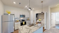 Located at 484 Greenmont Dr in Lewis Center, Ohio, this thoughtfully designed single-floor residence offers a efficient and modern layout. The open-concept kitchen and living area serves as the heart of the home, showcasing striking granite countertops with bold veining, crisp white shaker-style cabinetry, and stainless steel appliances including a refrigerator, range, and microwave. A central island with an undermount sink and stylish pendant lighting above adds both function and visual appeal, while durable wood-look flooring ties the space together seamlessly.

The living area benefits from vaulted ceilings that lend an airy, open feel, with a large window and glass-panel entry door that invite abundant natural light. Neutral-toned carpet provides a comfortable transition into the generously sized bedroom, which features dual windows, a ceiling fan, and warm, soft carpeting throughout. The walk-in closet is outfitted with wire shelving for organized storage. A conveniently located utility room accommodates a full-size washer and dryer. The overall palette of soft neutrals, clean lines, and modern finishes creates a bright, welcoming ambiance throughout the entire residence.