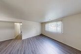 Located at 11650 Plaza Dr in Clio, Michigan, this 2-bedroom, 1-bathroom single-floor unit offers a practical and well-organized layout. The combined living and dining area serves as the heart of the home, featuring durable wood-look plank flooring and a large window with vertical blinds that allows natural light to fill the space, creating a bright and open atmosphere.

The kitchen is efficiently designed with warm wood-toned cabinetry, light granite-style countertops, a pass-through opening to the dining area, and white appliances including a range and refrigerator. A stainless steel sink and ample upper and lower cabinet storage complete the functional workspace.

Both bedrooms are carpeted and feature vertical blind-covered windows that bring in natural light. The primary bedroom is a comfortable size and includes access to a dedicated closet. The second bedroom also offers closet access, and the unit includes a total of three closets, providing generous storage throughout. A connecting hallway links the private areas of the home.

The full bathroom is clean and well-appointed, featuring a tub/shower combination, a white vanity with cabinet storage, a medicine cabinet mirror, and light wood-look flooring. The overall aesthetic is neutral and move-in ready, with white walls and clean finishes throughout.