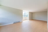 Located at 750 Wonderland Rd S in London, Ontario, this well-designed 2-bedroom, 2-bathroom unit offers a comfortable and functional layout across a single floor. Light hardwood flooring runs throughout the main living areas, complementing the neutral grey and white colour palette that gives the space a clean, modern feel.

The living room is a standout feature, wrapped in expansive floor-to-ceiling windows on two sides that flood the room with natural light and offer lush treetop views of the surrounding greenery. Baseboard heating runs along the window walls, ensuring comfort year-round.

The kitchen is efficiently laid out with sleek white cabinetry extending to the ceiling, a grey countertop with a double stainless steel sink, subway tile backsplash, and an integrated dishwasher — providing ample storage and a modern aesthetic.

The spacious primary bedroom features generous built-in sliding closets and its own window framing outdoor greenery. The second bedroom is a comfortable size with a window and its own natural light. Both bathrooms are finished consistently with light tile flooring, grey countertops, undermount sinks, and large vanity mirrors. One bathroom includes an accessibility grab bar. A utility room and hallway complete the thoughtful layout of this well-appointed unit.