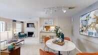 This single-story residence in Douglasville, Georgia offers a thoughtfully organized layout across two bedrooms and two full bathrooms. The open-concept living and dining area forms the heart of the home, where soft carpet flooring, a textured ceiling, and a tiled fireplace create a warm, inviting atmosphere. Track lighting illuminates the dining space, which flows seamlessly toward the kitchen via a pass-through bar with seating — ideal for casual dining or entertaining. The kitchen features warm wood cabinetry lining both sides of a galley-style corridor, white appliances including a range and refrigerator, and durable wood-look flooring for easy maintenance.

The living room benefits from natural light through large windows dressed with patterned drapes, complemented by a bold accent wall that adds visual interest. Both bedrooms offer plush carpet, ceiling fans, and dedicated closet space, with the primary bedroom providing a comfortable, well-proportioned retreat. The bathrooms include tub-shower combinations with clean, white surrounds. A dedicated in-unit laundry area accommodates a full-size washer and dryer with overhead shelving for storage, adding practical convenience to this well-appointed Douglasville residence.