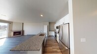 This single-floor residence offers a thoughtfully designed open-concept layout with wood-look flooring throughout. The kitchen is a central highlight, featuring white shaker-style cabinetry extending to the ceiling, granite countertops, a full suite of stainless steel appliances including a french door refrigerator, built-in microwave, and electric range, plus open display shelving. A generous island with an undermount sink and matching granite surface anchors the space and flows seamlessly into a spacious living area.

The living area is distinguished by large sliding glass doors that flood the space with natural light and frame a striking waterfront view. A corner fireplace adds a functional and aesthetic focal point to this room. Baseboard heating is present throughout the unit.

The bedrooms are well-proportioned, with one featuring a ceiling fan and window. Two bathrooms serve the unit: one full bath with a tub/shower combination and wood-look tile flooring, and a second bath with a white vanity, granite countertop, undermount sink, and dark hardware. Neutral wall tones and consistent finishes create a cohesive, modern ambiance throughout.