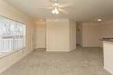 Located at 2100 Education Way in Oakwood, Georgia, this single-floor unit offers a well-organized and functional layout designed for comfortable everyday living. The open living area is a welcoming centerpiece, featuring vaulted ceilings, a ceiling fan, and large windows that invite abundant natural light and outdoor views. Neutral-toned carpet flows throughout, creating a cohesive and warm atmosphere.

The kitchen is positioned adjacent to the living area and is outfitted with warm oak cabinetry, dark granite-style countertops, a tile floor, and a full suite of white appliances including a range, refrigerator, dishwasher, and built-in microwave. A pass-through counter connects the kitchen to the living space, enhancing the open feel.

The bedrooms are generously sized, each carpeted and filled with natural light from well-placed windows. Closet space is provided in each room, with at least one bedroom featuring a walk-in closet. The bathrooms are practically appointed with white vanities, dark countertops, large mirrors, and tub/shower combinations with tiled surrounds. One bathroom includes a high window above the tub, adding a touch of natural light. Throughout the unit, neutral beige walls and clean finishes contribute to a bright, move-in-ready environment.