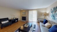 This well-appointed one-bedroom, one-bathroom residence at Ravens Crest in Plainsboro, NJ, offers a thoughtfully designed single-floor layout with a comfortable and functional living environment. The living room serves as the heart of the home, featuring warm hardwood flooring, a classic fireplace with a tile surround, and a large sliding glass door framed by vertical blinds that floods the space with natural light and provides access to the outdoors. A dedicated sitting area with additional hardwood flooring completes the living space. The kitchen is equipped with rich wood cabinetry, dark granite-style countertops, stainless steel appliances including a refrigerator and range, and track lighting overhead — offering both style and practicality. The bedroom is a peaceful retreat, featuring plush carpeting, a neutral accent wall, generous natural light from a window overlooking greenery, and ample space for furnishings. The bathroom includes a clean white vanity and connects to a hallway with a louvered closet door, providing convenient storage. Throughout the residence, neutral tones and consistent finishes create a cohesive, inviting ambiance well-suited for comfortable everyday living.