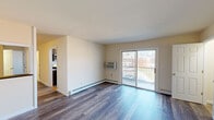 This single-floor residence at 13 Bradford Ave in Trenton, New Jersey, offers a thoughtfully laid-out interior finished with consistent wood-style plank flooring throughout, lending a cohesive and contemporary feel to the space.

The living area is generously sized, featuring a sliding glass door that opens to a private balcony, allowing natural light to fill the room while providing outdoor views of the surrounding neighborhood. A wall-mounted air conditioning unit and baseboard heating ensure year-round comfort. An adjacent room, visible through an open pass-through, offers flexibility as a dining area or additional living space.

The kitchen is well-appointed with dark cabinetry lining both sides of the galley-style layout, stainless steel appliances including a gas range and a full-size refrigerator, light stone-look countertops, and a window that brings in natural light. Storage is plentiful with upper and lower cabinets throughout.

The bedrooms are comfortably sized, with large windows dressed in blinds that provide ample natural light and privacy. Baseboard heating is present in each room. The bathroom features a full soaking tub with a tiled surround, a showerhead, and a window for ventilation. The overall ambiance is clean, neutral, and move-in ready.