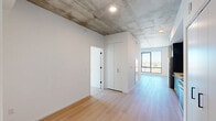 This modern 2-bedroom, 2-bathroom residence at 625 North 2nd Avenue in Phoenix, AZ offers a well-designed single-level layout with a compelling blend of industrial and contemporary aesthetics. Exposed concrete ceilings contrast strikingly against crisp white walls and light wood-tone flooring that flows throughout the unit, creating a clean, urban atmosphere.

The open-concept kitchen and dining area is outfitted with dark, flat-panel cabinetry, white quartz countertops, a subway tile backsplash, and a full suite of stainless steel appliances including a gas range and built-in microwave. A pantry provides additional storage. The living area is bright and open, benefiting from large floor-to-ceiling windows that frame panoramic views of the Phoenix skyline and surrounding neighborhood.

Both bedrooms are well-proportioned, each featuring the same exposed concrete ceiling detail, light flooring, and generous closet space with clean white built-in cabinetry. Floor-to-ceiling windows in the bedrooms flood each room with natural light and offer elevated city views. The two bathrooms are finished with large-format white tile walk-in showers and matte black fixtures, lending a polished, minimalist feel. A dedicated laundry area and entrance complete this thoughtfully configured urban residence.