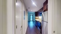This contemporary 500 square foot apartment in Silver Spring, Maryland, offers a harmonious blend of style and functionality. The space is expertly designed to maximize efficiency in its one-bedroom, one-bathroom layout. Upon entry, you're greeted by rich, dark wood flooring that flows throughout the apartment, creating a warm and cohesive aesthetic.

The kitchen is a highlight, featuring sleek dark wood cabinetry, stainless steel appliances, and a stylish backsplash. Granite countertops add a touch of luxury, while ample storage space ensures practicality. The open-concept design seamlessly connects the kitchen to the living area, enhancing the sense of spaciousness.

The living room is bathed in natural light from large windows, creating an inviting atmosphere. A unique frosted glass panel adds an architectural element while maintaining privacy. The 130 square foot bedroom offers a cozy retreat with a built-in closet for storage.

The bathroom is elegantly appointed with neutral-toned tiles, a modern vanity, and a shower/tub combination. The overall design prioritizes clean lines and a minimalist aesthetic, resulting in a space that feels both contemporary and timeless. This apartment at Eleven55 Ripley is perfect for those seeking a modern, low-maintenance living space in a prime location.