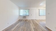 Located at 7845 Stewart and Gray Rd, Unit 29 in Downey, CA, this efficiently designed one-bedroom, one-bathroom unit offers a clean, modern aesthetic across its single-floor layout. Light-toned luxury vinyl plank flooring runs consistently throughout, unifying the space and contributing to its bright, open feel.

The combined kitchen and living area forms the heart of the unit. The kitchen features white shaker-style cabinetry with matte black hardware, white quartz countertops, a classic subway tile backsplash, and a full suite of stainless steel appliances including a gas range, refrigerator, and microwave. The living area benefits from multiple windows dressed with vertical blinds, allowing ample natural light, and includes a wall-mounted air conditioning unit.

The spacious primary bedroom is a comfortable retreat, fitted with a ceiling fan, a large window overlooking greenery, and a mirrored closet that adds depth to the room.

The bathroom stands out with floor-to-ceiling marble-style wall panels surrounding a soaking tub, complemented by elegant brushed gold fixtures that add a touch of luxury. A window provides natural ventilation and light. Throughout the unit, crisp white walls and consistent flooring create a cohesive, move-in-ready environment.