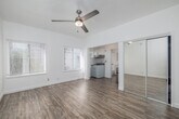 Located at 123 E Windsor Rd in Glendale, CA, this single-floor studio unit offers a thoughtfully arranged layout that maximizes every inch of its compact footprint. The main living area is bright and airy, featuring light-toned hardwood-style flooring, crisp white walls, and a ceiling fan with a built-in light fixture that adds both function and character. Large windows fitted with blinds allow generous natural light to fill the space, creating an open and welcoming atmosphere.

The kitchenette flows seamlessly from the living area and is equipped with white cabinetry, a tile backsplash, an under-cabinet range hood, and a compact stove and sink. A stainless steel mini-refrigerator is conveniently positioned nearby. A mirrored sliding-door closet provides practical storage while visually expanding the space.

The bathroom is clean and well-appointed, featuring a full bathtub and shower combination with chrome fixtures, a single vanity with a sink, a wall-mounted mirror, and a window that brings in natural light. The unit also includes a wall-mounted HVAC unit near the entry door, ensuring year-round climate control. The overall aesthetic is clean, minimal, and functional, making this studio an efficient and comfortable living space in a convenient Glendale location.