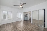 Located at 123 E Windsor Rd in Glendale, CA, this single-floor studio unit offers a thoughtfully arranged layout that maximizes every inch of its compact footprint. The main living area is bright and airy, featuring light-toned hardwood-style flooring, crisp white walls, and a ceiling fan with a built-in light fixture that adds both function and character. Large windows fitted with blinds allow generous natural light to fill the space, creating an open and welcoming atmosphere.

The kitchenette flows seamlessly from the living area and is equipped with white cabinetry, a tile backsplash, an under-cabinet range hood, and a compact stove and sink. A stainless steel mini-refrigerator is conveniently positioned nearby. A mirrored sliding-door closet provides practical storage while visually expanding the space.

The bathroom is clean and well-appointed, featuring a full bathtub and shower combination with chrome fixtures, a single vanity with a sink, a wall-mounted mirror, and a window that brings in natural light. The unit also includes a wall-mounted HVAC unit near the entry door, ensuring year-round climate control. The overall aesthetic is clean, minimal, and functional, making this studio an efficient and comfortable living space in a convenient Glendale location.