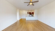 This well-appointed two-bedroom, two-bathroom residence at 410 Northline Road in Ballston Spa, New York offers a thoughtfully designed single-floor layout. The open-concept living and kitchen area serves as the heart of the home, featuring warm hardwood-style flooring, bright neutral walls, and a ceiling fan that enhances the airy feel. The kitchen is highlighted by rich dark cabinetry, granite countertops, a subway tile backsplash, stainless steel appliances, and a generous island with pendant lighting — ideal for both cooking and casual dining. Sliding glass doors lead from the living area to a private balcony, allowing for natural light and outdoor views. Both bedrooms are carpeted and well-lit by large windows with outdoor views, offering a comfortable and quiet retreat. The spacious primary bedroom provides ample room for furnishings. The two bathrooms are finished with large-format tile flooring, dark wood vanities with granite countertops, and a sliding glass-door shower enclosure. A dedicated laundry room with a full-size washer and dryer adds everyday convenience. The space combines functional design with clean, modern finishes throughout.